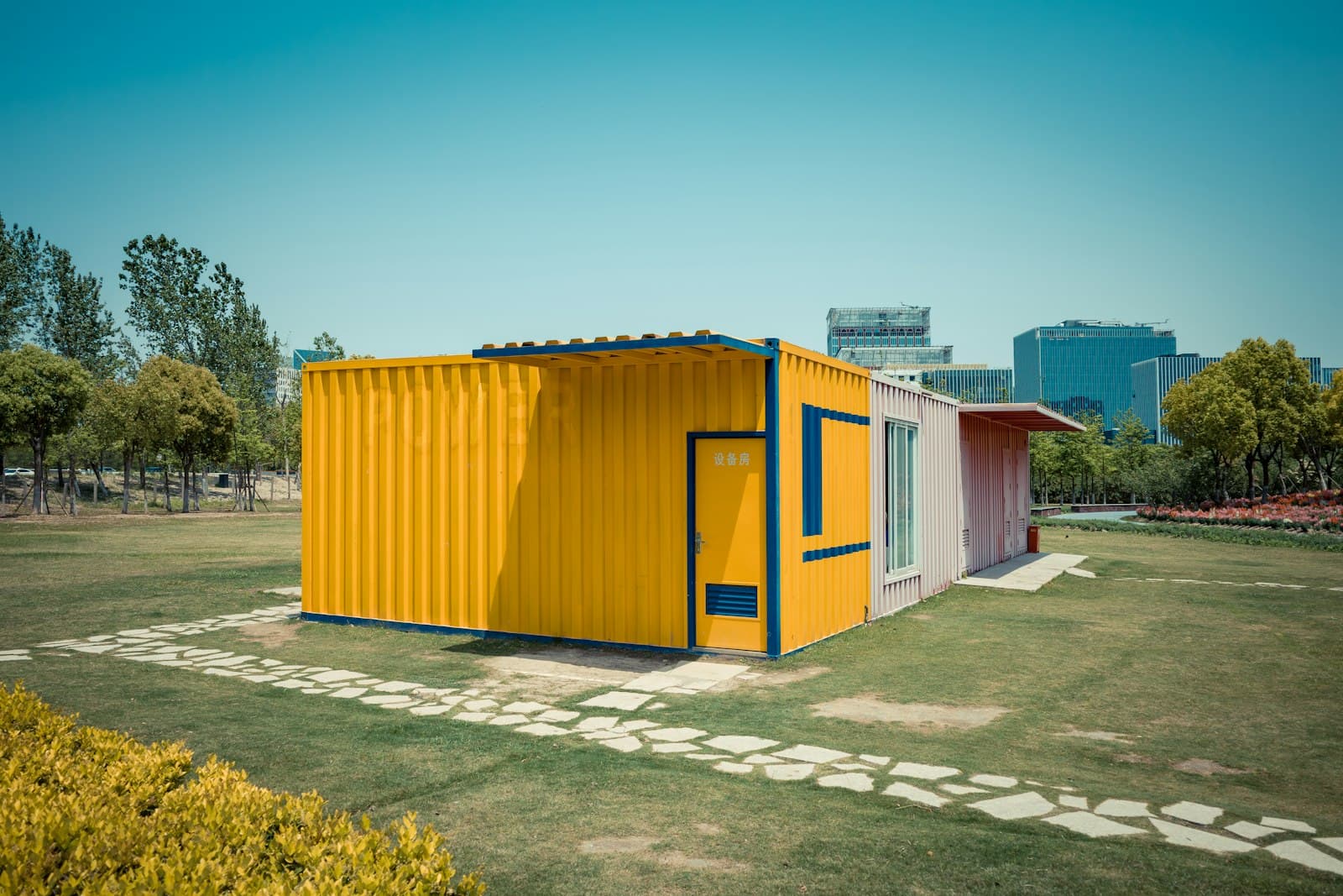 Módulo de container pintado de amarelo num gramado